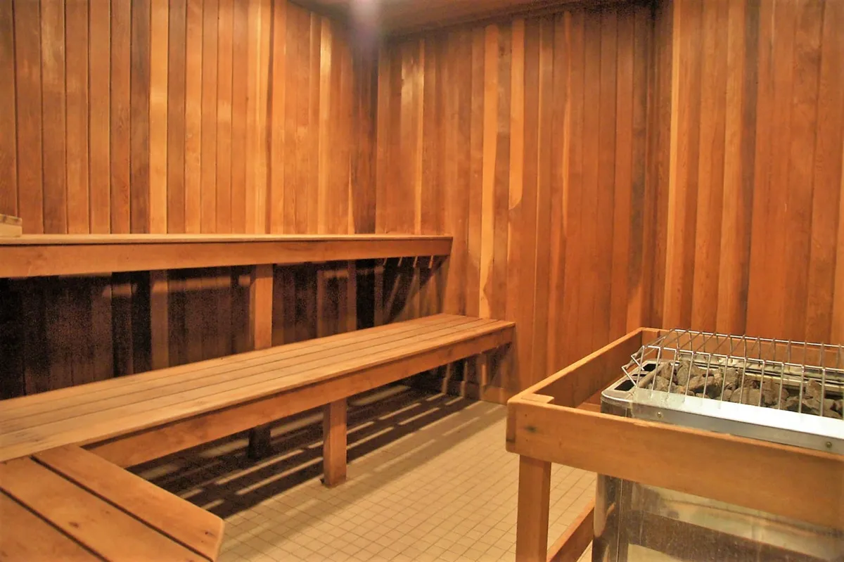 A calming interior sauna with wooden benches and a sauna heater, inviting guests to experience deep relaxation and rejuvenation.