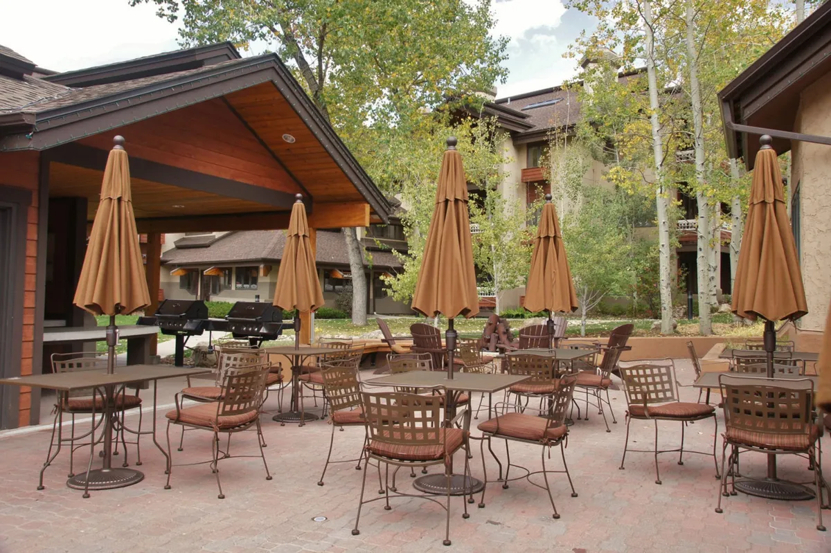 An inviting outdoor seating area with umbrellas and a clear pathway, perfect for dining or socializing. The scene exudes a casual, lively ambiance ideal for group gatherings and evening conversations under the sky.